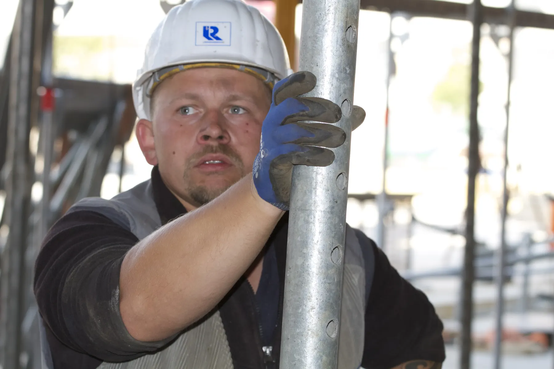 Facharbeiter richtet ein Gerüstelement auf der Baustelle aus