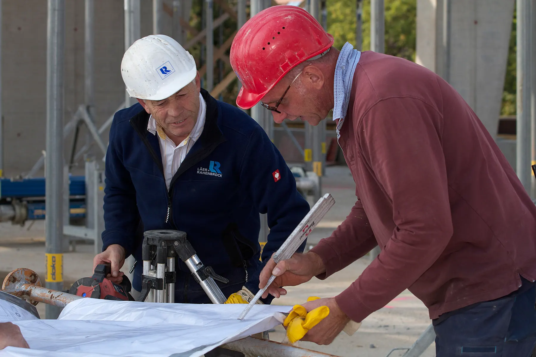 Bauleiter und Architekt besprechen gemeinsam Pläne auf der Baustelle